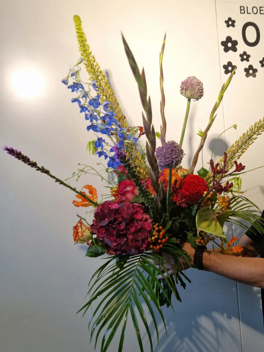 The owner of Bloemenhuis Orchidee with a large bouquet