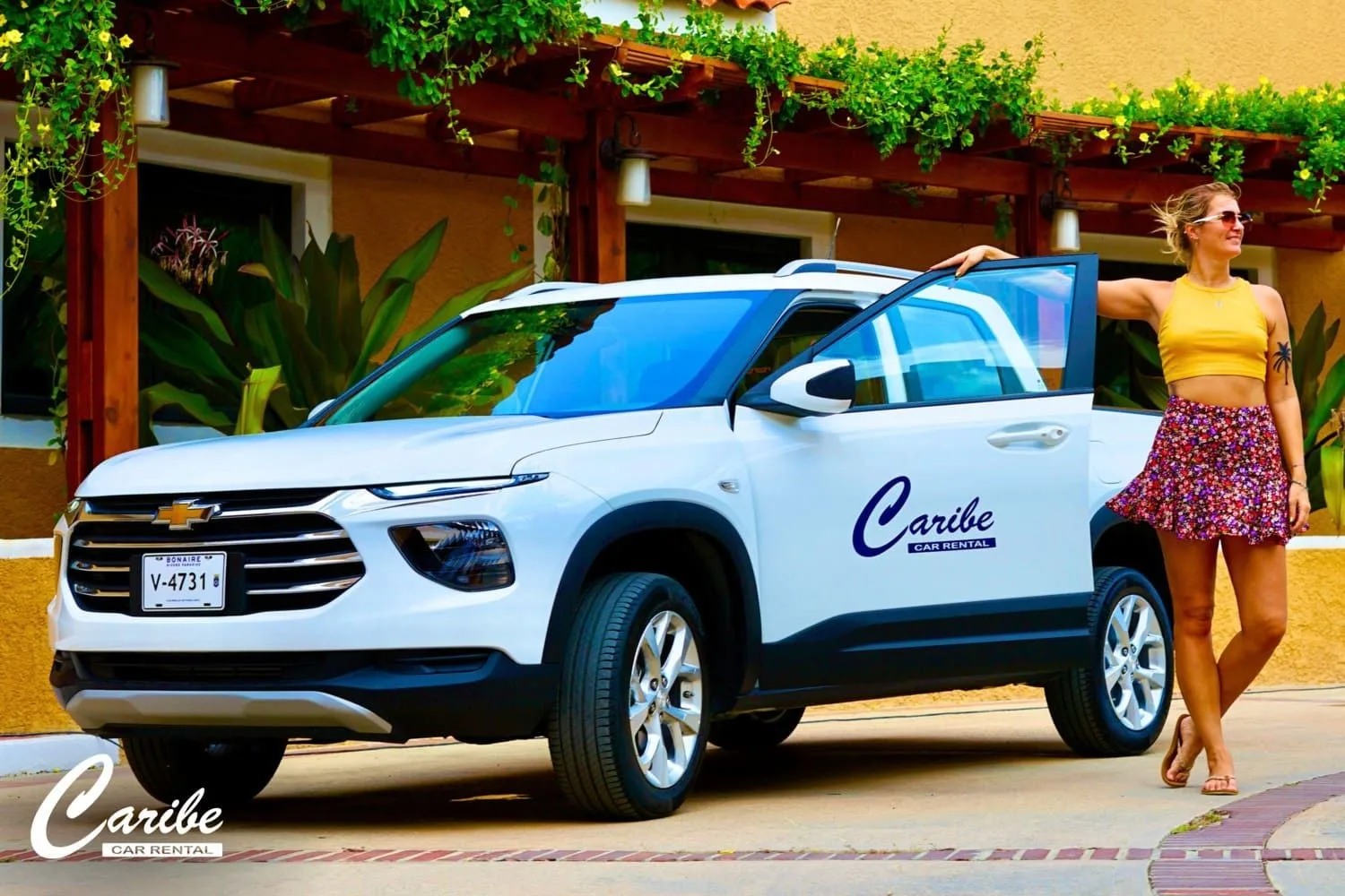 A white Caribe Car Rental car in a courtyard on Bonaire